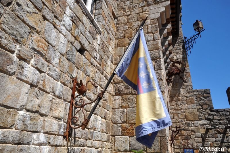 Castello Di Amorosa: флаг с львами и лилиями на каменной стене